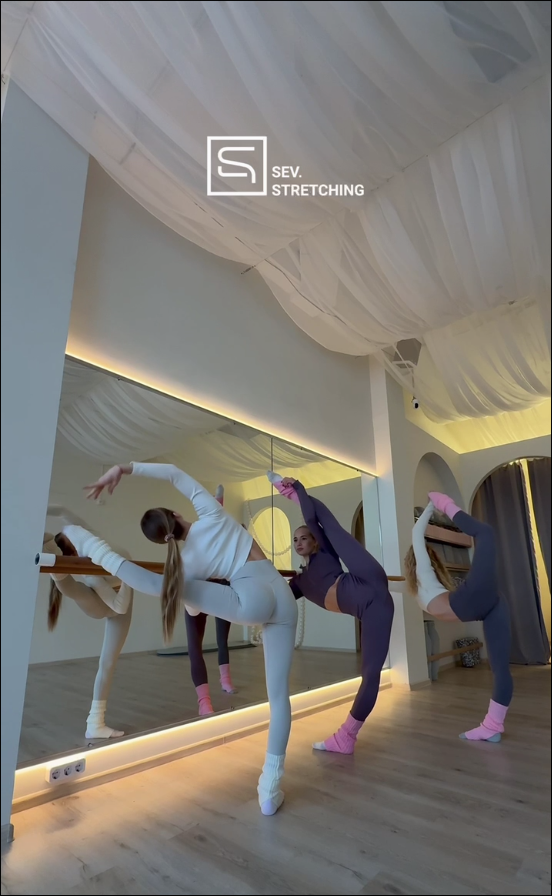 Занятие растяжкой у станка в светлом зале SEV. STRETCHING